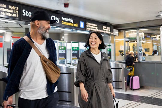 en man och en kvinna utanför spärrarna i Stockholm tunnelbana