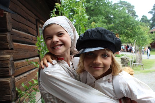två barn utklädda i gammeldags kläder