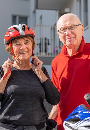 en man och en kvinna som står bredvid sina cyklar med sina hjälmar